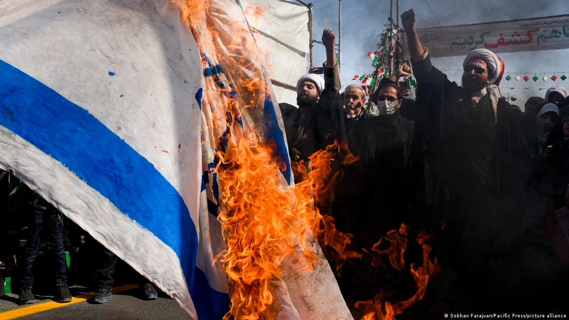 متظاهرون في طهران يحرقون العلم الإسرائيلي خلال الاحتقال بالذكرى السنوية للثورة الإسلامية في شهر شباط/فبراير 2023.  Foto: Sobhan Farajvan/Pacific Press/picture alliance Demonstranten in Teheran verbrennen eine israelische Flagge