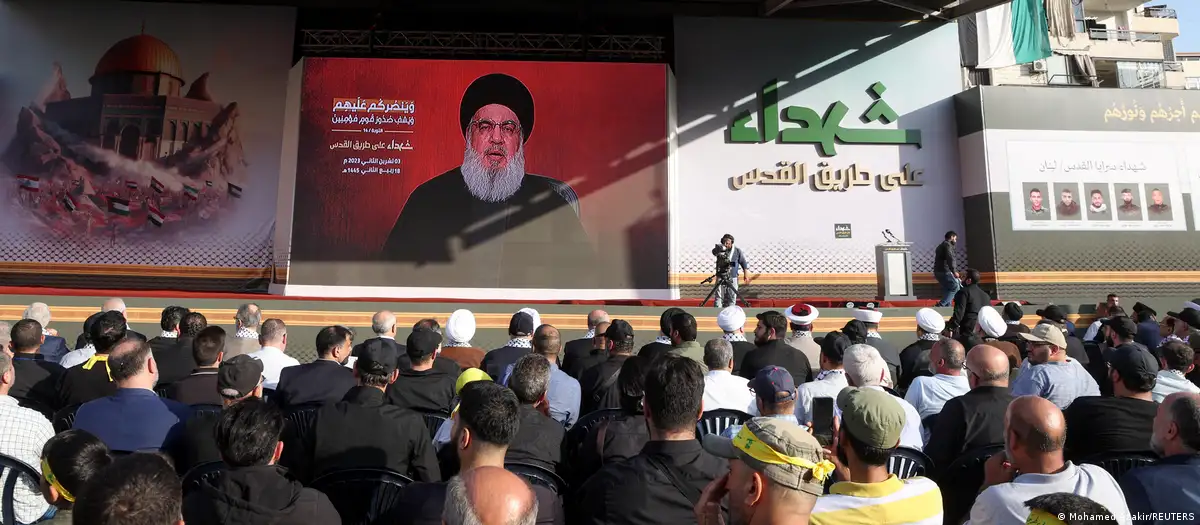 Hezbollah leader Hassan Nasrallah seen on a screen addressing a crowd of supporters