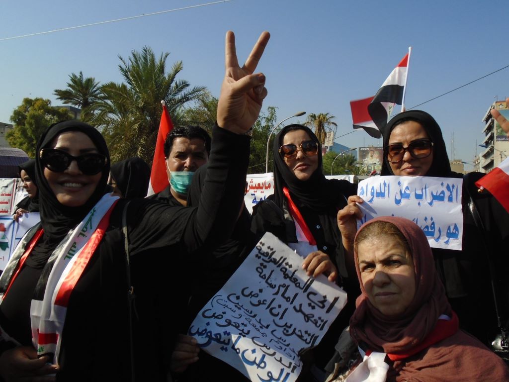 Women dressed in black carrying placards and Iraqi flags demonstrating on Tahrir Square in Baghdad, Iraq in 2019