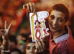 Libysches Kind hält Karikatur hoch, das Muammar al-Gaddafi und dessen Sohn Seif al-Islam am Galgen zeigt; Foto: dapd