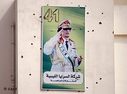 A portrait of Moammar Gadhafi on a wall covers by bullets marks is displayed on a building in the Abu Salim district, in Tripoli, Libya, Friday, Aug. 26, 2011 (photo: dapd)