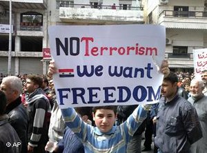 Ein Junge hält bei einer Anti-Regierungsdemonstration in Banias ein Plakat, auf dem steht: 'We want Freedom, no Terrorism'; Foto: AP