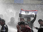 An Egyptian protester flashes Egypt's flag as anti-riot policemen use water cannons against protesters in Cairo (photo: dapd)