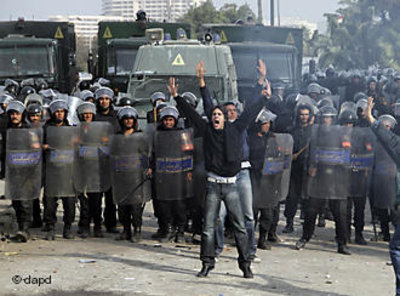 An Egyptian protester shouts in front of anti-riot policemen blocking a bridge in Cairo (photo: dapd)