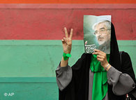 An Iranian woman in Tehran holds a photo of Mir Hossein Mousavi in front of her face (photo: AP)