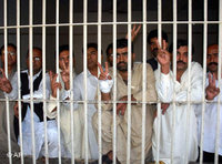 Unidentified Pakistani protesters flash victory signs from a police lock-up facility in Multan, 7 November 2007 (photo: AP)