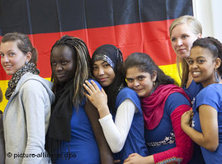 Young Germans in front of Germany's national flag (photo: picture-alliance/dpa)