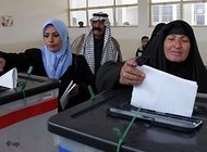 Two women cast their votes at a polling station in Baghdad (photo: AP)