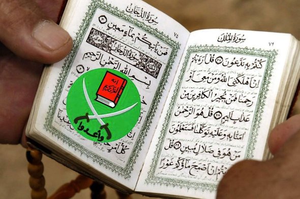 Mann liest Koran mit Symbol der Muslimbruderschaft als Lesezeichen; Foto: dpa