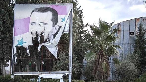 A damaged poster of Bashar al-Assad in Aleppo on 8 December 2012 (photo: Narciso Contreras/AP/dapd)