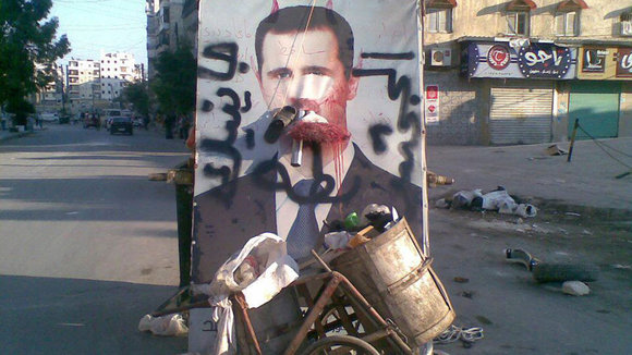 Ein Poster von Bashar al-Assad neben Mülltonnen in Aleppo; Foto: Reuters