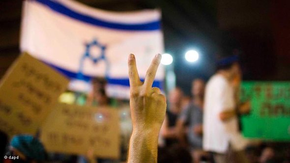 Demonstrant macht Victory-Zeichen vor Israelfahne; Foto: dapd