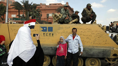Demonstranten auf dem Tahrir-Platz machen Fotos von einem Panzer nach Mubaraks Rücktritt; Foto: AP