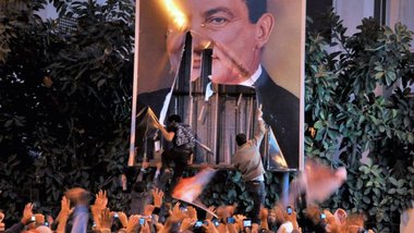 In Alexandria wird ein Plakat Mubaraks zerstört; Foto: dpa