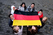 Kids holding the German flag (photo source: Federal Office for Migration and Refugees)