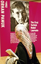 Frau mit Kopftuch vor Plakat von Orhan Pamuk auf der Frankfurter Buchmesse