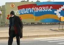 Mann passiert Mauer mit Flagge der selbst ernannten Republik Berg-Karabach; Foto: AP