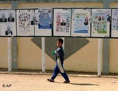 Junge vor Wahlplakaten; Foto: AP