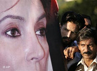 Pakistaner hinter einem überlebensgroßen Plakat von Benazir Bhutto; Foto: AP