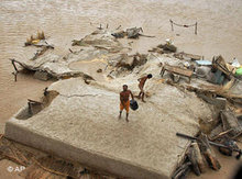 Flutopfer stehen auf ihrem von Wassermassen umschlossenen Haus in Taunsa in der Nähe von Multan; Foto: AP