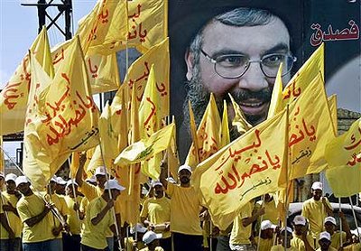 Anhänger der Hizbullah vor einem Plakat von Hassan Nasrallah; Foto: AP
