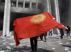 Demonstranten mit Nationalfahne Kirgistans stürmen den Regierungssitz in Bischkek; Foto: AP