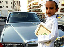 Kleiner saudischer Junge mit Koran unterm Arm; Foto: dpa