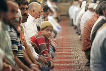 Junge in der Gebetsreihe einer Moschee; Foto: dpa