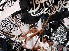Indonesische Jugendliche von der islamistischen Gruppierung Hizbut Tahrir schwenken Fahnen mit islamischer Schrift; Foto: AP 