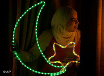 Eine junge Muslimin in Ramallah schaut aus einem geschmückten Fenster während Ramadan; Foto: AP