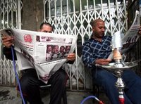Iraqi newspaper-readers in Baghdad (photo: AP)