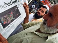 Two Pakistanis are reading the newspaper