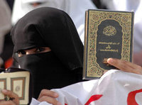 امراه ترفع  نسخة من القرآن، الصورة: ا.ب