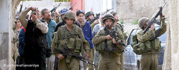 جنود إسرائيليون يقومون بحماية المستوطنين في مدينة الخليل، الصورة: د.ب.ا