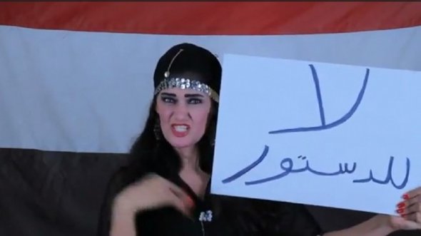 Sama al-Masri hält Schild mit der Aufschrift 'Nein zur Verfassung'; Foto: youtube