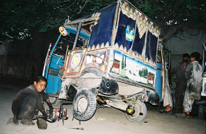 Kind aus Kabul repariert ein Fahrzeug