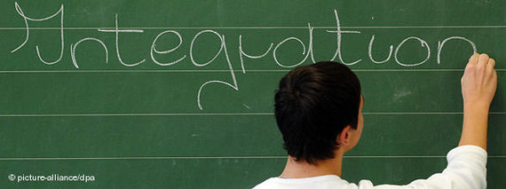 Schüler schreibt das Wort Integration auf eine Tafel; Foto: dpa