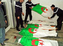 Algerian police force cover the bodies of the dead in the Algerian national flag after an attack by militant Islamists (photo: AP)