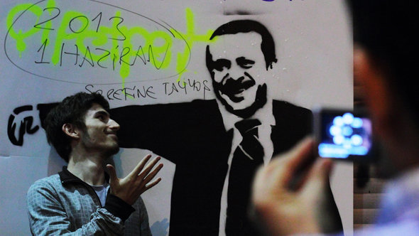 Aktivist vor Erdogan-Grafitti in Istanbul; Foto: Gaia Anderson