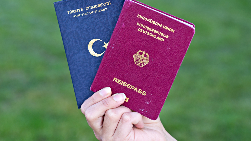  Eine Studentin zeigt  türkischen Pass (l.) und deutschen Reisepass; Foto: picture-alliance/dpa