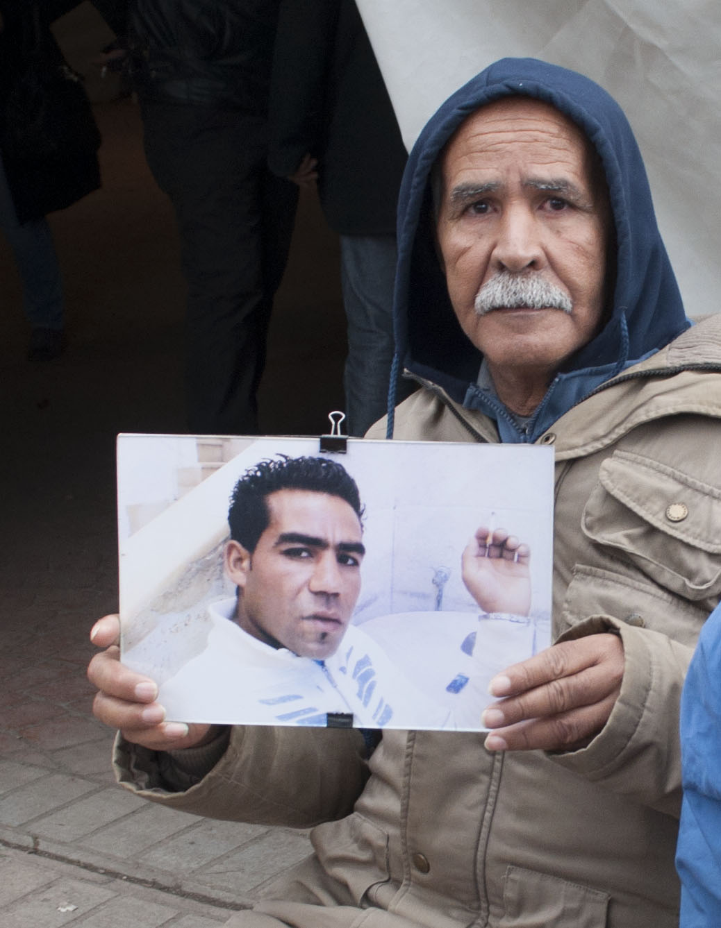 Mohamed hält Plakat mit dem Bild seines getöteten Sohnes während einer Demonstration von Angehörigen der Revolutionsopfer in Tunis hoch; Foto: Sarah Mersch 