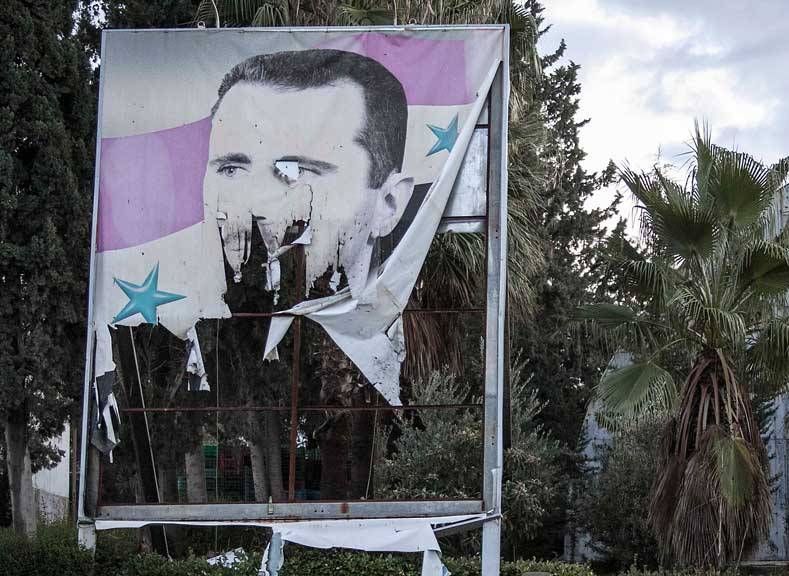 صورة ممزقة لبشار الأسد في مدينة حلب شمال سوريا. Foto: AP