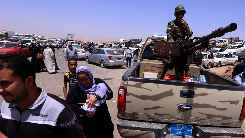Flüchtlinge aus Mossul und Kämpfer der kurdischen Peschmerga am Checkpoint in Aski Kalak; Foto: Safin Hamed/AFP/Getty Images