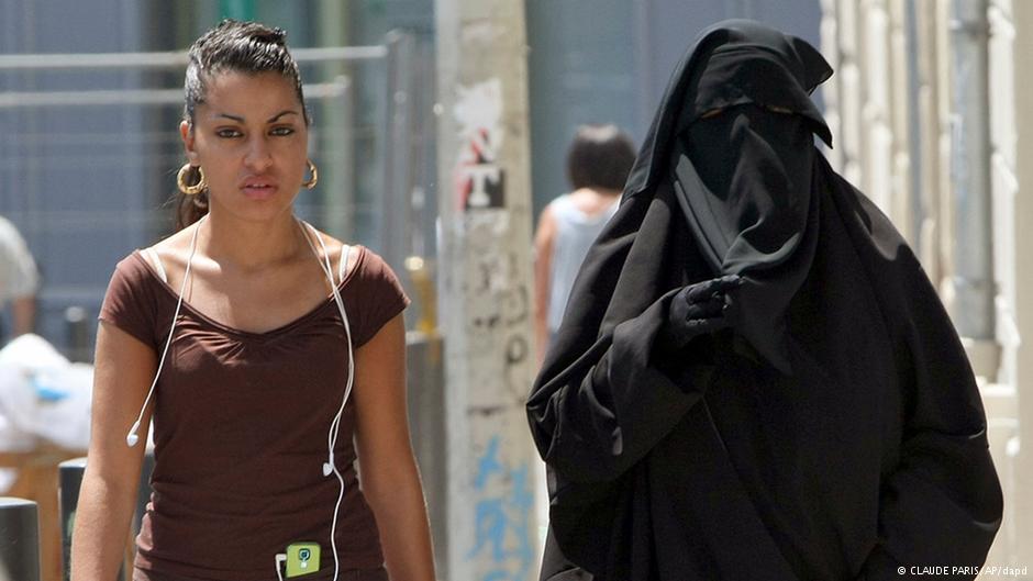 A fully-veiled woman in Paris walking in the street alongside a woman in a T-shirt. Claude Paris/AP/dapd
