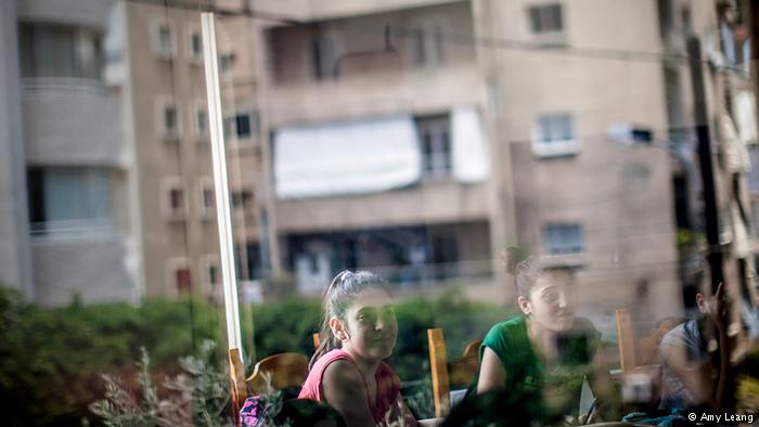 Die Wohnhäuser der Schüler spiegeln sich in den Fensterscheiben der Schule. Viele sehen die Schule als zweites Zuhause; Foto: Amy Leang