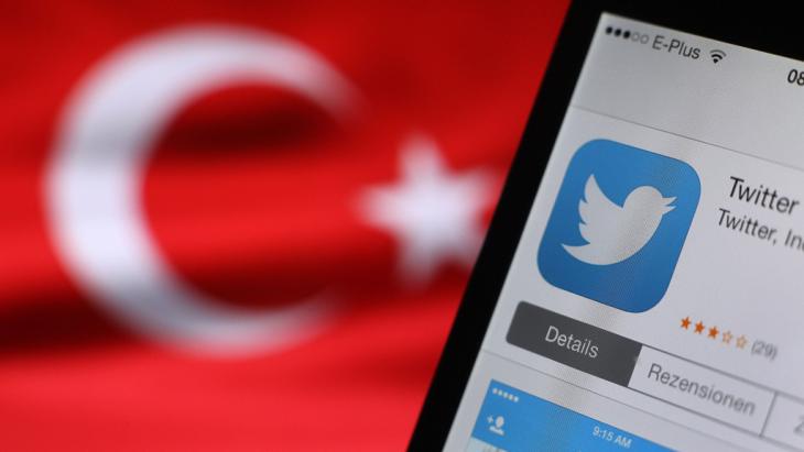 The Twitter logo is seen on a smartphone screen; in the background, a Turkish flag (photo: dpa/picture-alliance)