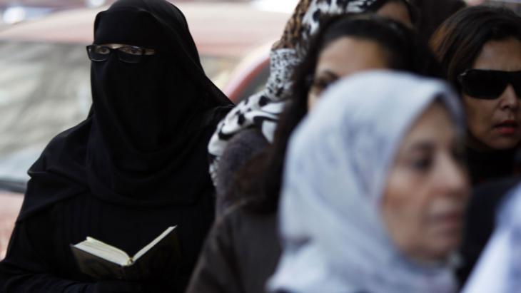An Egyptian woman wearing a niqab and reading a Koran (photo: Reuters)