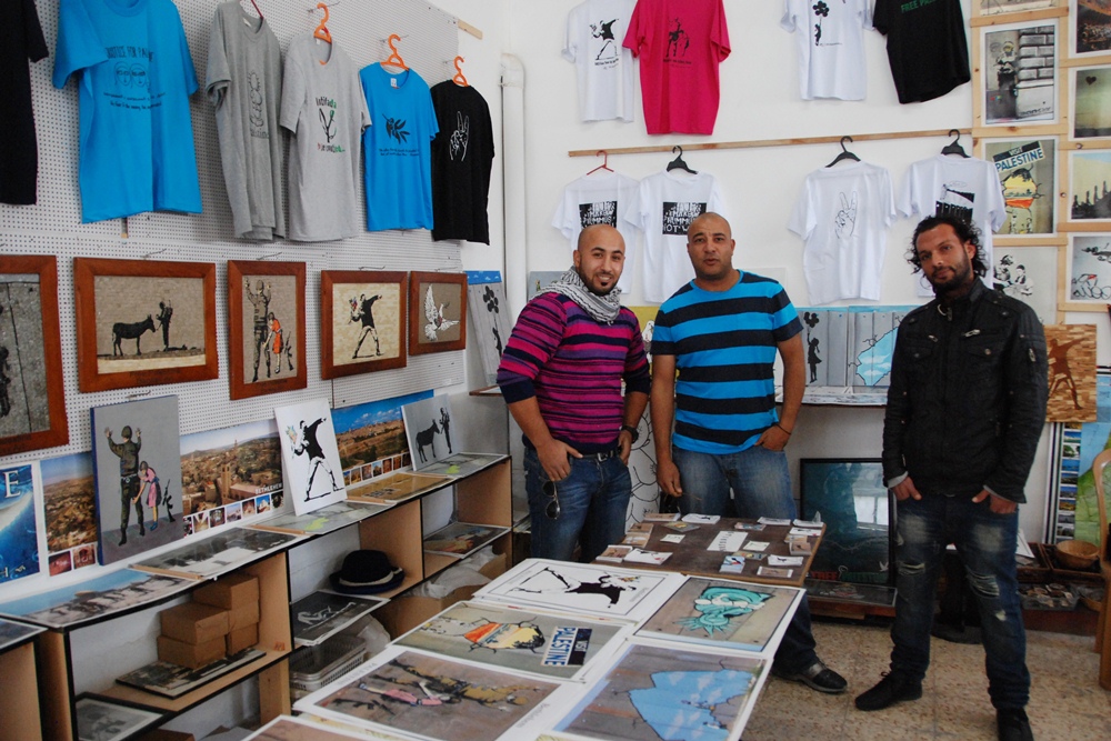 Yamen Elabed (Mitte) gemeinsam mit zwei Kollegen in seinem Souvenir-Laden "Banksy’s Shop" in Bethlehem; Foto: Laura Overmeyer