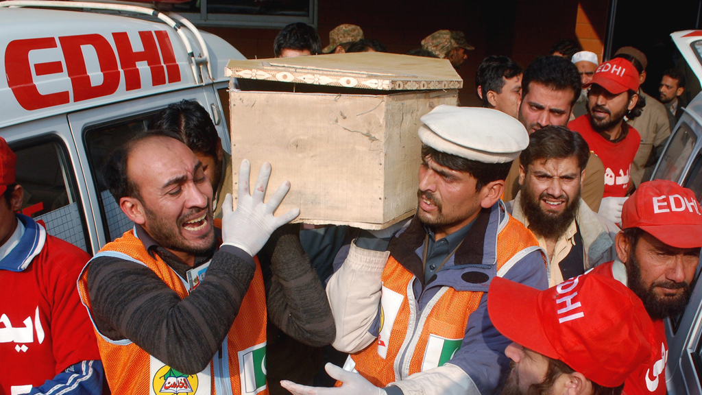Rescue workers and family members carry the coffin of a student killed during an attack by Taliban gunmen on the Army Public School in Peshawar, 16 December 2014 (photo: Reuters/K. Parvez)