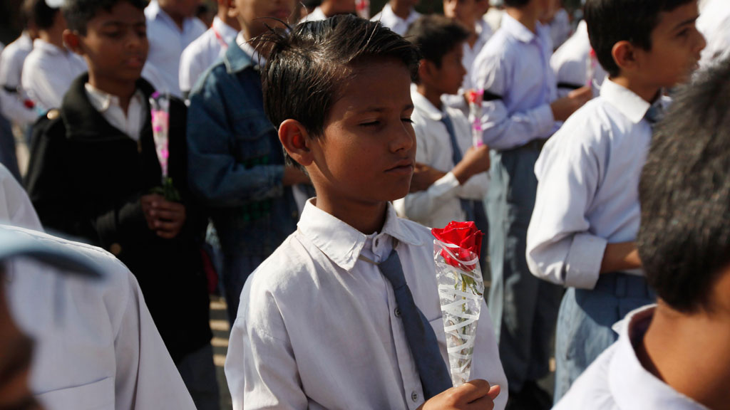 A student holding a rose takes part in a prayer for victims of the Taliban attack on the Army Public School in Peshawar, 17 December 2014 (photo: Reuters/A. Soomro)